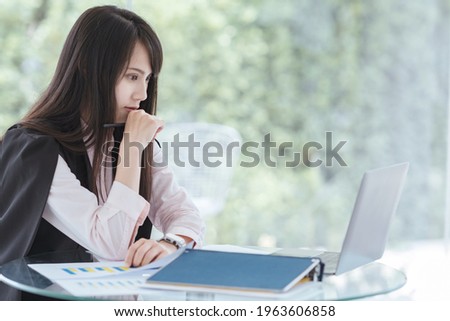 Blur picture about Young business woman sitting on desk thinking about her job with laptop  at workplace.Copy space of business woman concept.
