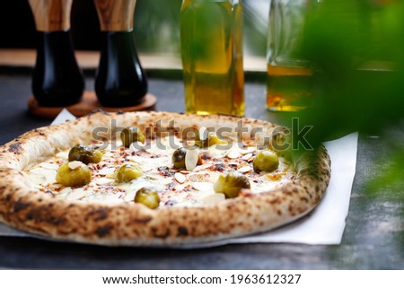 Pizza with gorgonzola cheese, brussels sprouts and roasted almonds.
Culinary photography. Proposal for dishes.