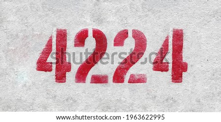 Red Number 4224 on the white wall. Spray paint.