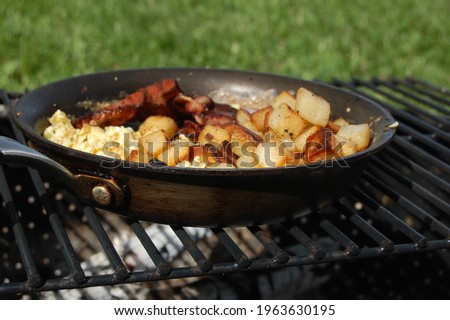 Campfire Breakfast Cooking Cast Iron Skillet Royalty-Free Stock Photo #1963630195