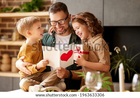 We love you, dad. Young happy father getting congratulations on Fathers Day from two excited kids at home, son and daughter, smiling children giving daddy handmade postcard and wrapped gift box