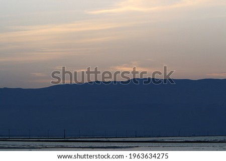 Dead Sea at dawn and the first ray of sun rising over the mountains in Jordan.