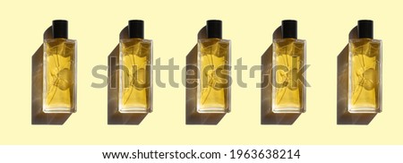 five transparent bottles of woman perfume with shadows on yellow pastel background. top view. flat lay. banner. mockup of luxury perfume bottles
