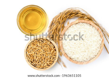 Rice bran oil extract with white rice and paddy rice isolated on white background. Top view. Flat lay. Royalty-Free Stock Photo #1963651105