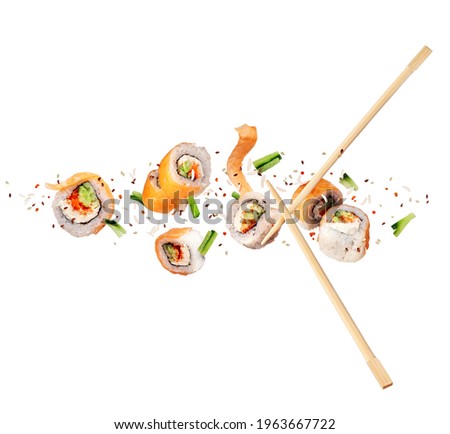 Fresh sushi rolls with salmon in the air on white background
