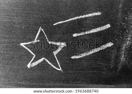 White color chalk hand drawing as star shape on blackboard or chalkboard background
