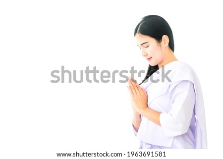 Buddhist Asian woman in white dress praying and worship on white background. Young calm female relax and practicing meditation. Copy Space. Royalty-Free Stock Photo #1963691581
