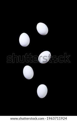 White chicken eggs fall. Black background. Levitation. Protein nutrition concept. Creativity. High quality photo