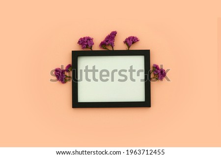 Black frame with flowers on a pink background.