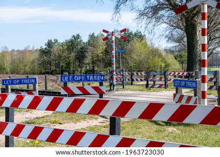 Unguarded railway crossing for cyclists and pedestrians, with text please note train