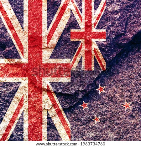 Grunge UK and New Zealand vertical national flags icon pattern isolated together on weathered rock wall background, abstract UK New Zealand political relationship solid as rock concept wallpaper