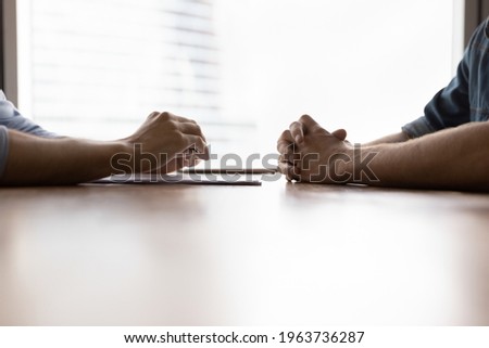 Close up crop view of determine male rivals or opponents opposite face each other talk about business at meeting. Businessmen or business partners engaged in negotiations in office. Rivalry concept. Royalty-Free Stock Photo #1963736287
