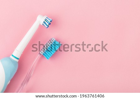 electric and manual toothbrushes on the pink background