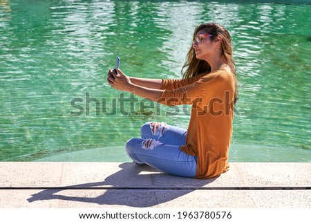 Young woman brunette taking selfie on swimming pool