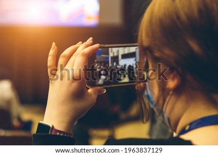 Woman taking picture on smartphone at meeting