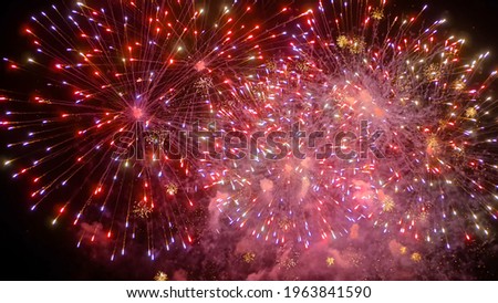 Holiday, celebration and anniversary concept. Colorful bright fireworks in dark sky at night. Evening time, low light illumination