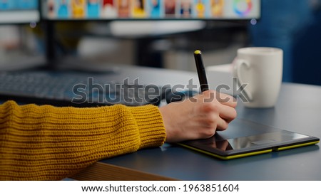 Close up of photo editor freelancer editing customer photo using computer with two displays drawing on graphic tablet. Graphic photographer retouching assets in creative agency with stylus pencil