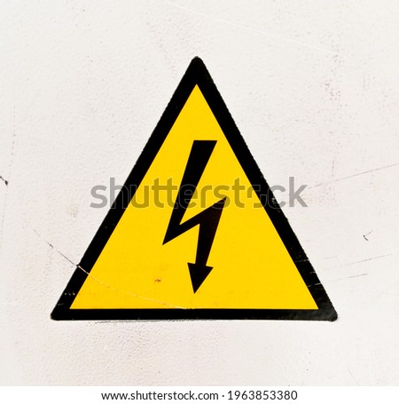 yellow and black high voltage warning sign on white background