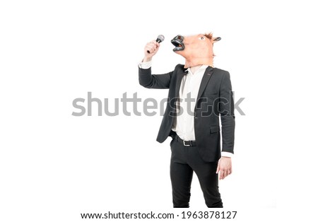 Professional man wear horse head mask in formalwear singing karaoke song to microphone isolated on white copy space, costume party. Royalty-Free Stock Photo #1963878127