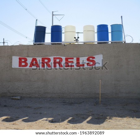 Six 6 Barrels sitting on a wall