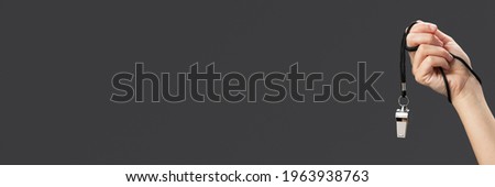 Female referee hand with whistle close up Royalty-Free Stock Photo #1963938763