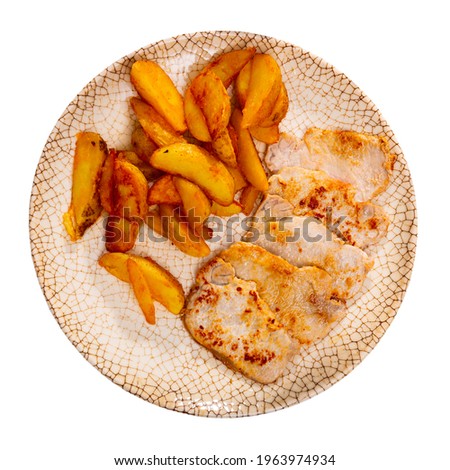 A picture of a pork chop on a plate of fried potatoes. Isolated over white background
