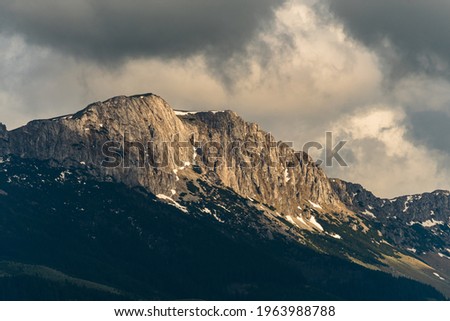 The Beautiful View of a Mountain Peak Covered by Clouds near Sunset	