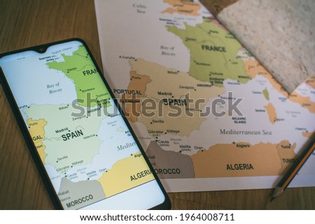 Smart Phone And Travel Map Of Europe. Top View. Vacation And Tourism Concept