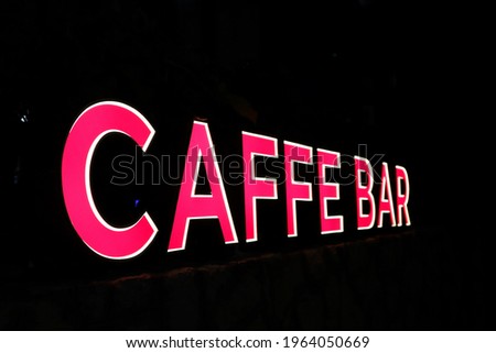 Illuminated advertisement for a coffee bar in the dark