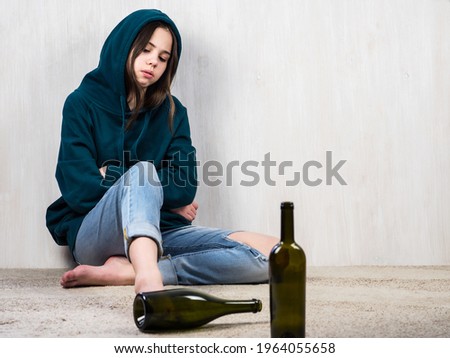 Alcohol abuse. Psychology. Depressed and intimidated teenage girl against alcohol. The concept of alcohol addiction among adolescents. Family aggression. Royalty-Free Stock Photo #1964055658