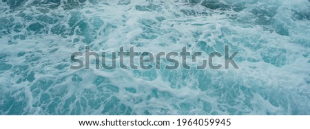 Photography of surf in Gran Canaria. Big waves of the Atlantic Ocean runs onto the sandy shore in summer day. Natural fresh background for poster, banner, postcard, greeting card, touristic guide