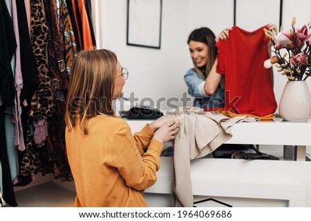 Beautiful young woman paying her new clothes buyed in expensive boutique.