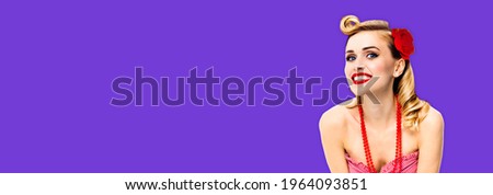 Excited surprised, happy smiling beautiful woman. Portrait of pin up blond girl at studio. Retro and vintage concept picture. Violet purple color background. Wide banner composition. Rockabilly style.