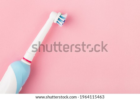 electric toothbrush on pink background. Dental care