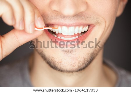 clean and floss space between tooth with plastic and silicone interdental brush to get leftover out of mouth is part of daily hygiene and health care routine to remove plaque Royalty-Free Stock Photo #1964119033