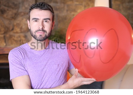 Man holding large red balloon representing his ego
