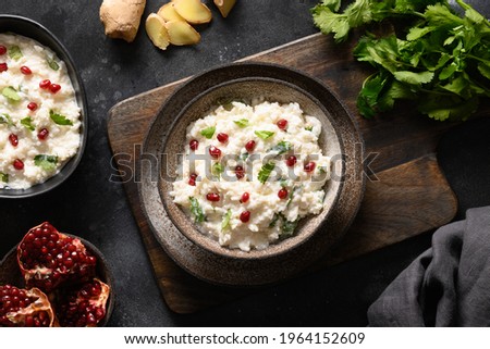 Homemade Curd Rice with pomegranate, cilantro, ginger on a black background. Top view. Traditional Indian South cuisine Royalty-Free Stock Photo #1964152609