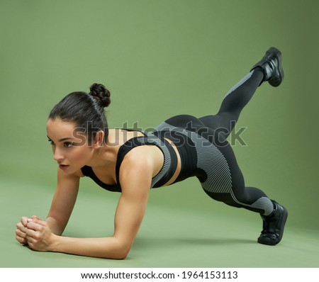Sporty young woman working out in studio