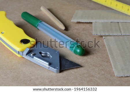 tools for working with cardboard laid out on a table with cardboard scraps.