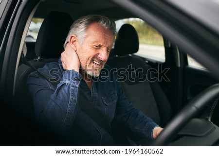 Senior man inside car after road traffic accident in pain suffering with whiplash injury Royalty-Free Stock Photo #1964160562