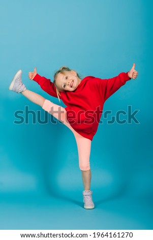 Portrait of a cheerful girl jumping and dancing against studio background