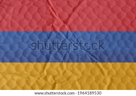 The National Flag of the Republic of Armenia on an uneven textured surface. Freedom, independence concept.