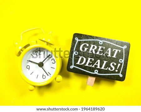 Text GREAT DEALS with alarm clock on yellow background.
