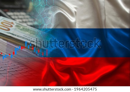 national flag of Russia on satin, dollar bills, computer, concept of global trading on the stock exchange, falling and rising prices for world currency Royalty-Free Stock Photo #1964205475