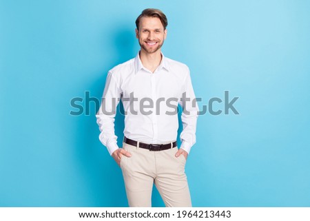 Photo of happy positive young man hold hands pants pockets smile isolated on pastel blue color background