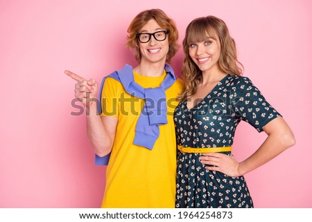 Photo portrait of guy embracing girl pointing blank space advising smiling isolated on pastel pink color background