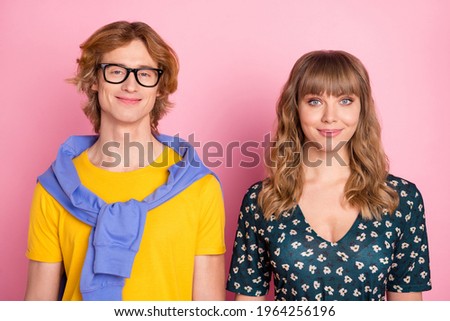 Photo of two satisfied optimistic young persons smile look camera isolated on pastel pink color background