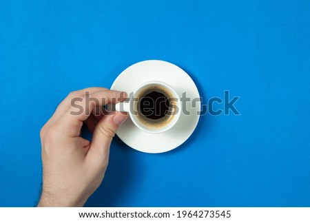 Top view of man hand holding a cup of coffee over flatlay. Concept photo of the start of a new good day. Concept flat lay design for banner or blog.