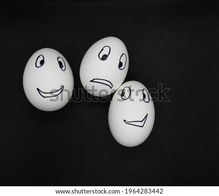 Emotions on white eggs on a black background.