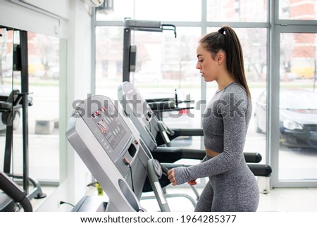 Young female athlete exercising in gym 
